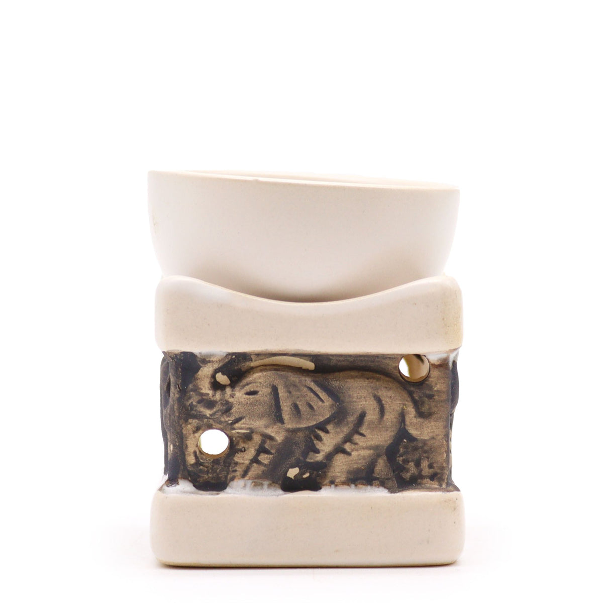 Cream ceramic oil burner with a carved elephant panel on the front