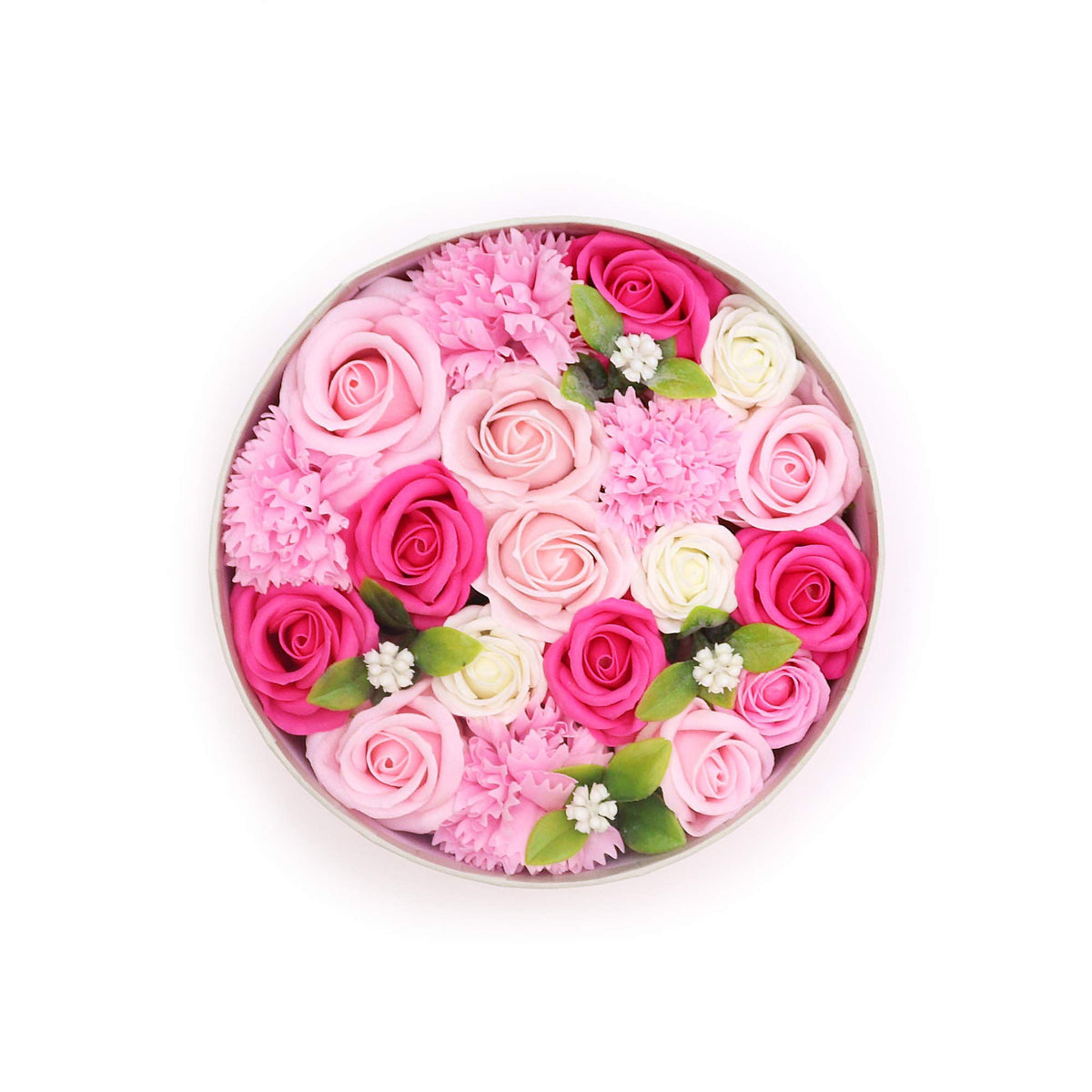 Open round box of pink, pale pink and cream flower-shaped soaps, viewed from above on white