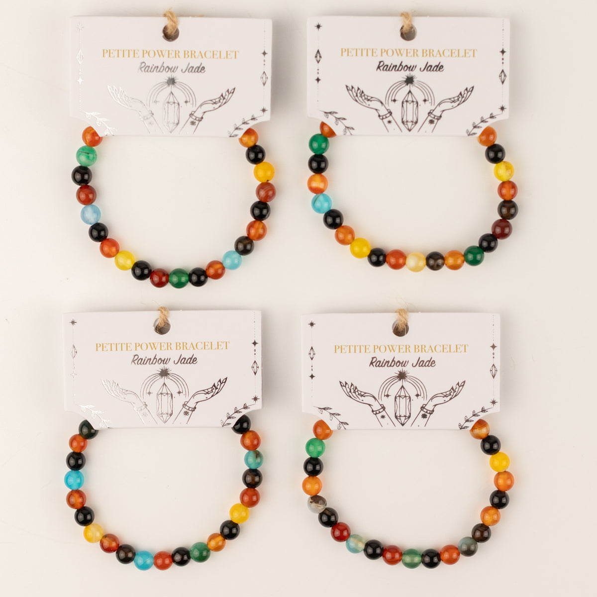 Four Rainbow Jade bracelets on illustrated presentation cards