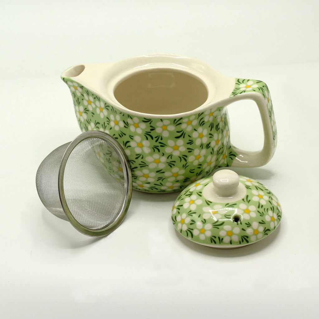 Green daisy teapot shown open with lid and metal strainer beside it