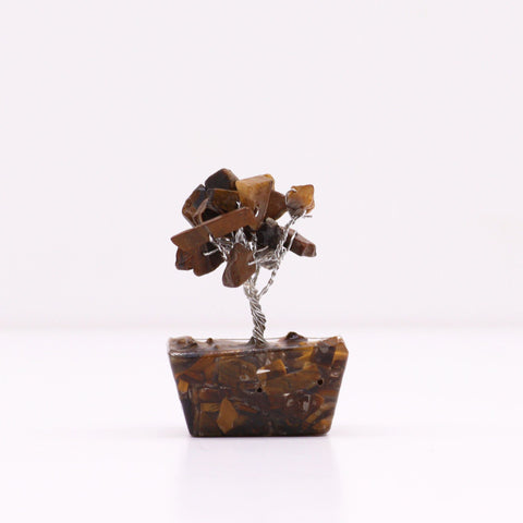 Tigereye gemstone tree viewed from the side against a plain white background
