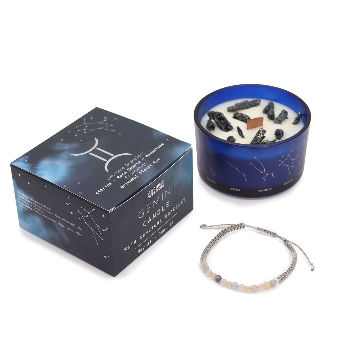 Close view of a zodiac candle top, dark crystal chunks and the wick, jar printed with the constellations