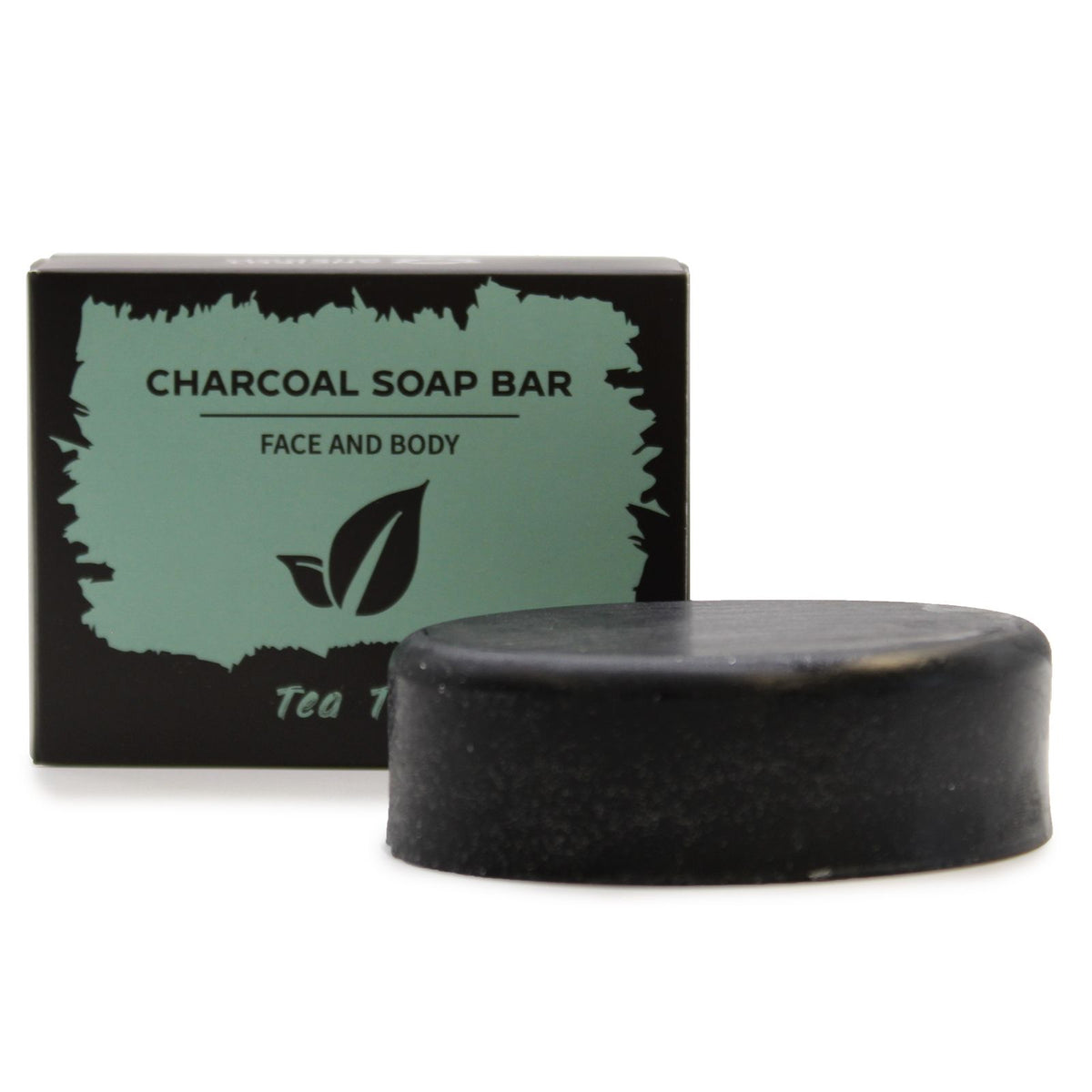 Black tea tree charcoal soap bar in front of its pale green box, shown side by side