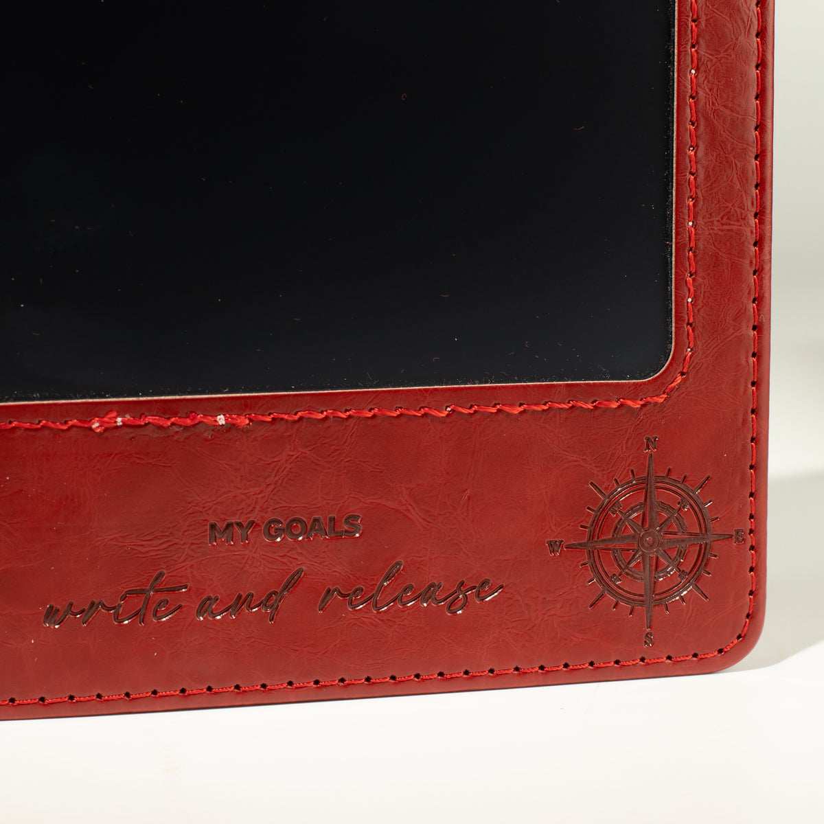Close-up of the red notebook’s stitched screen border