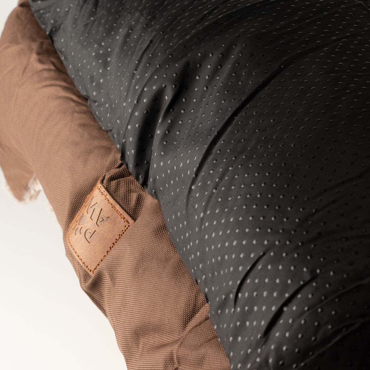 Close view of the bed's brown outer fabric and base