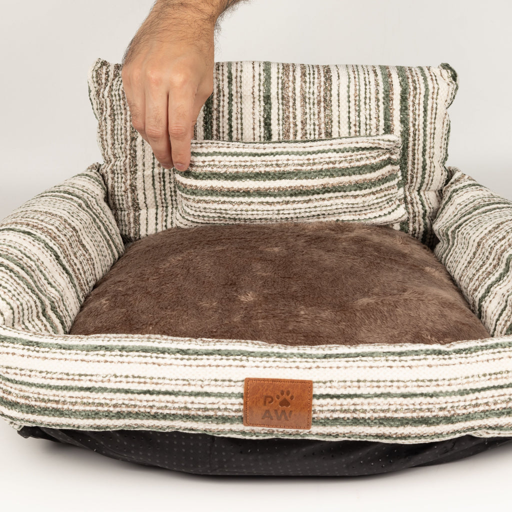 Hand lifting the small matching cushion from the pet bed