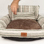 Hand lifting the small matching cushion from the pet bed