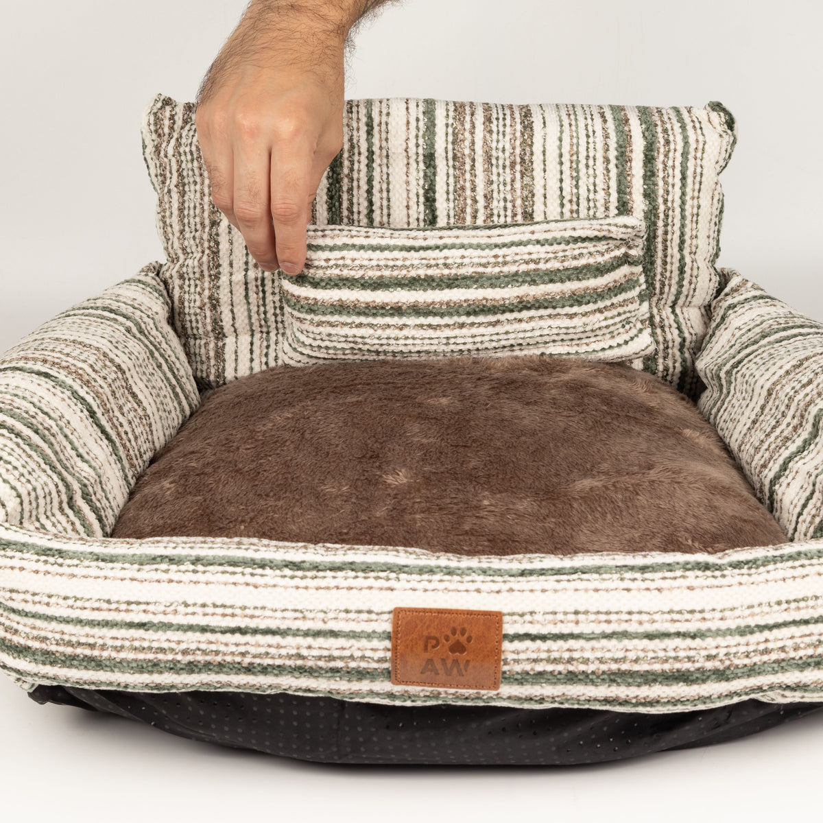Hand lifting the small matching cushion from the pet bed