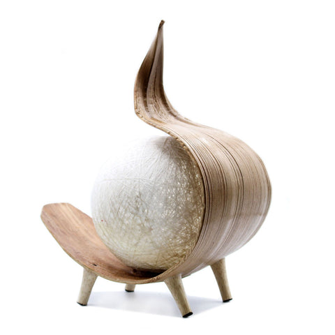Natural Coconut Lamp, Chocolate Twist with a pale glowing globe in a curved brown shell on three feet