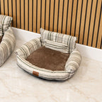 Close view of the striped pet bed and its rounded armrests