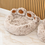 Raised paw toes and brown pads on the bed