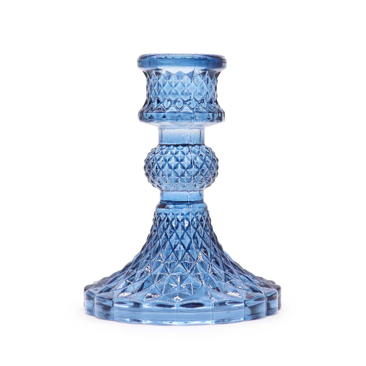 Royal blue glass candle holder shown alone in a close-up, highlighting its raised patterned base and stem