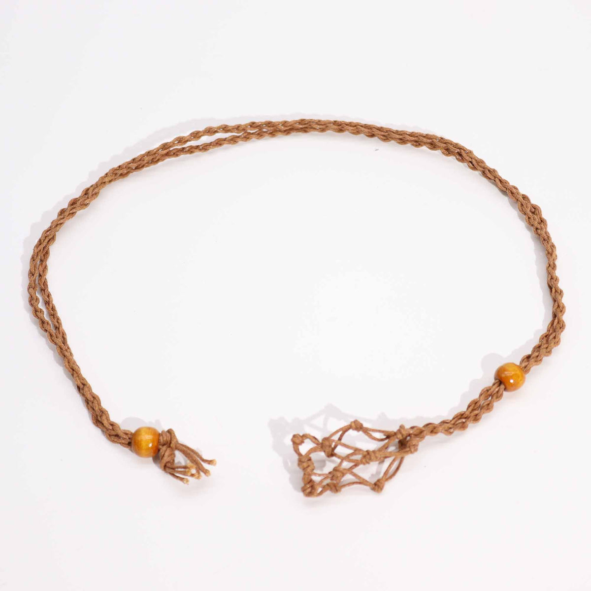 Brown gemstone necklace cord laid out in a loop on white, showing its knotted ends and two beads