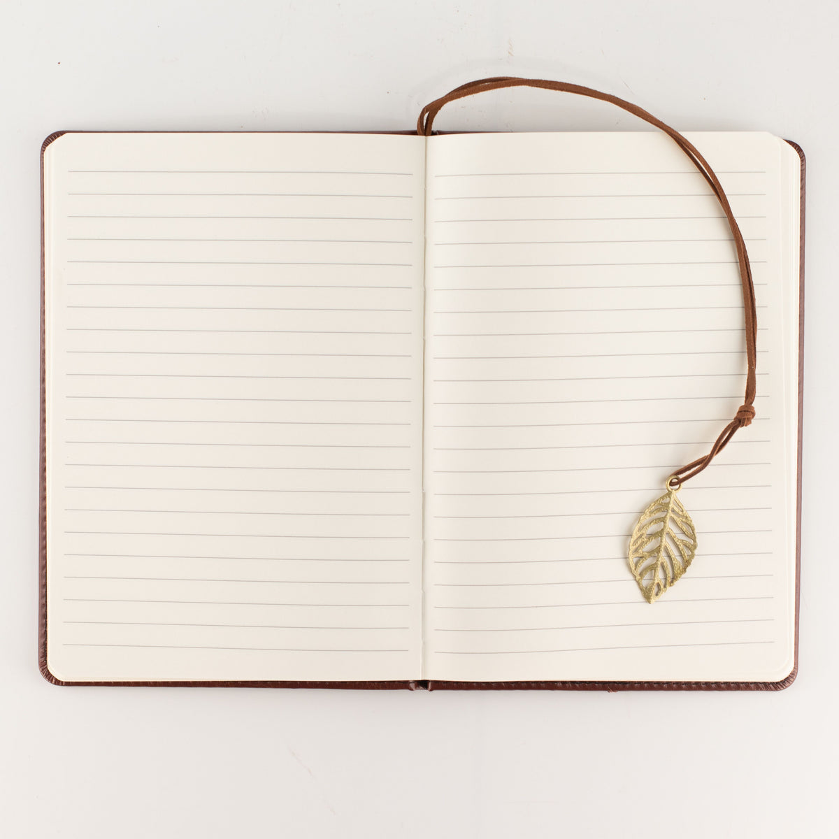 Notebook opened to show lined pages and leaf bookmark