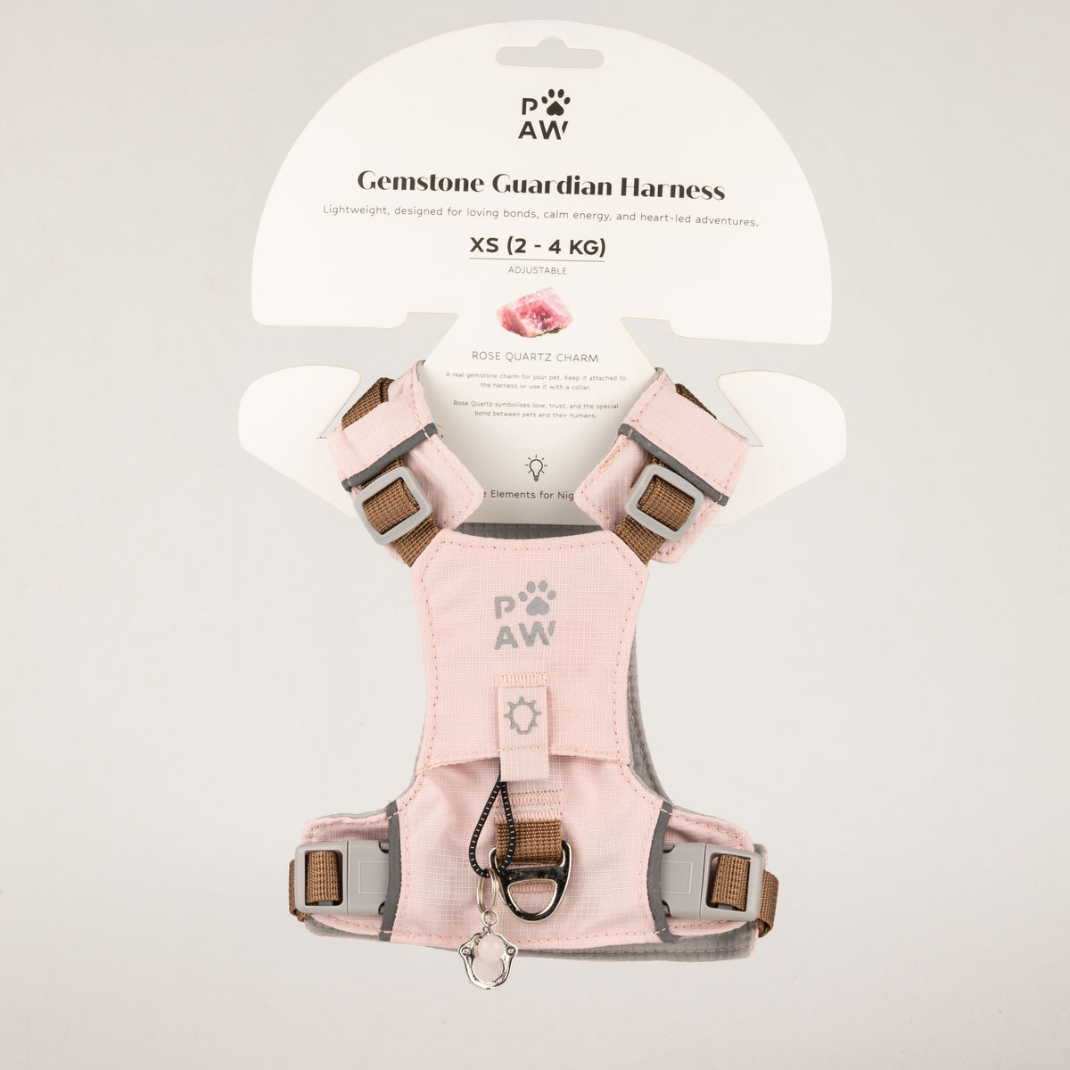 PAW soft pink dog harness with reflective details and paw charm, shown on packaging