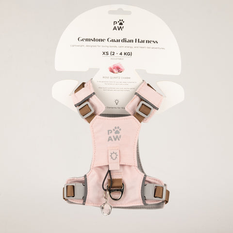 PAW soft pink dog harness with reflective details and paw charm, shown on packaging