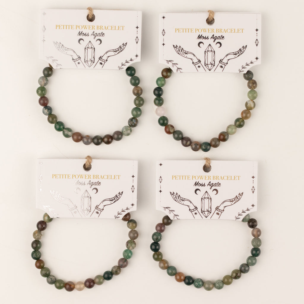 Several Moss Agate bracelets displayed on illustrated cards