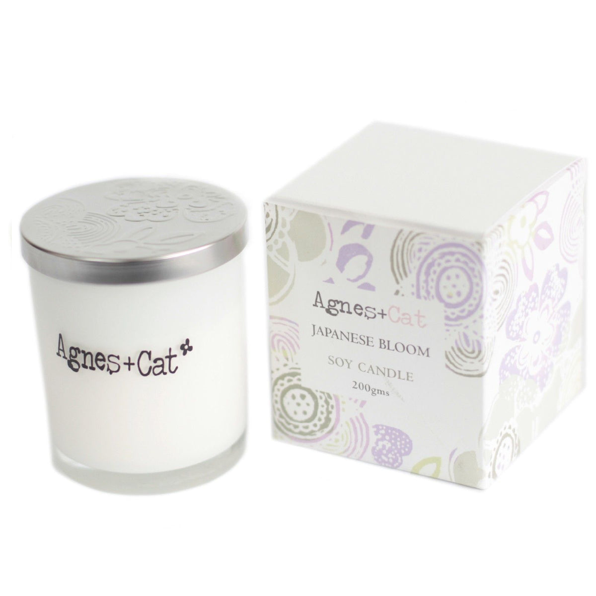 Agnes + Cat Votive Candle, Japanese Bloom, white glass candle with silver lid beside its patterned box