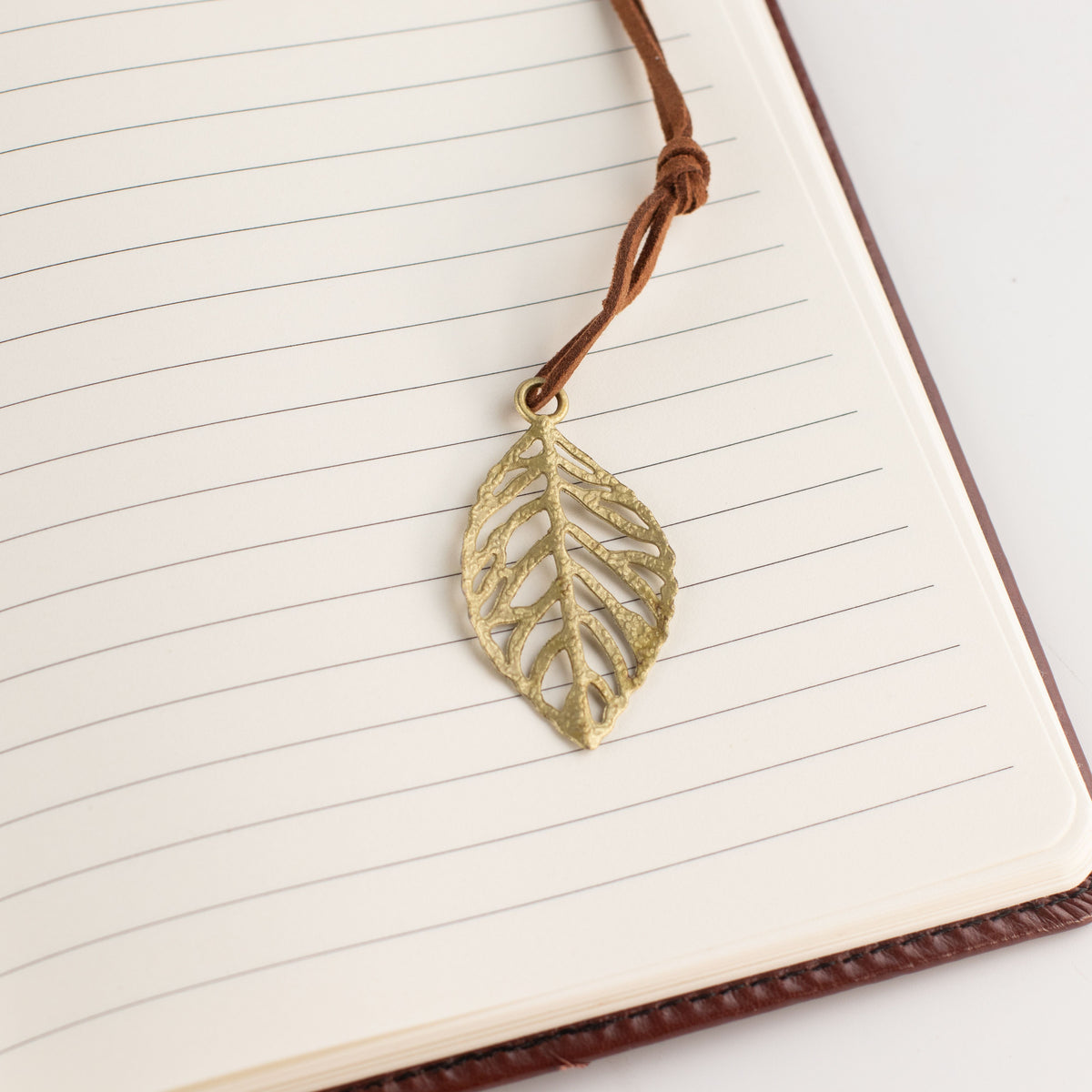 Close-up of the leaf-shaped bookmark on a lined page