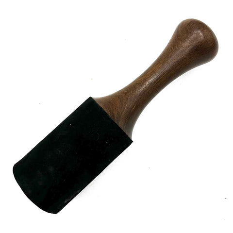 Large wooden stick with a brown handle and black end, shown diagonally against a white background