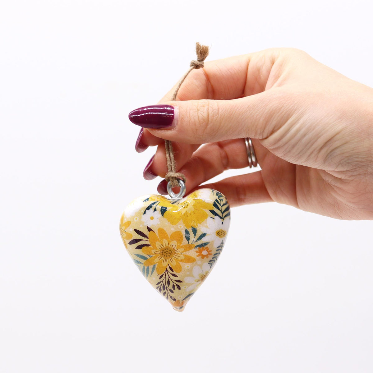Lrg Decor Wood Heart, Yellow Floral held by a hand, showing its yellow floral design and hanging twine