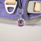 Close-up of the purple paw charm hanging from the harness