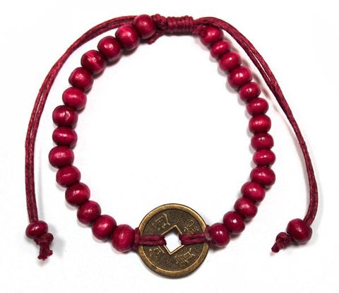 Red beaded bracelet with a coin charm in the centre