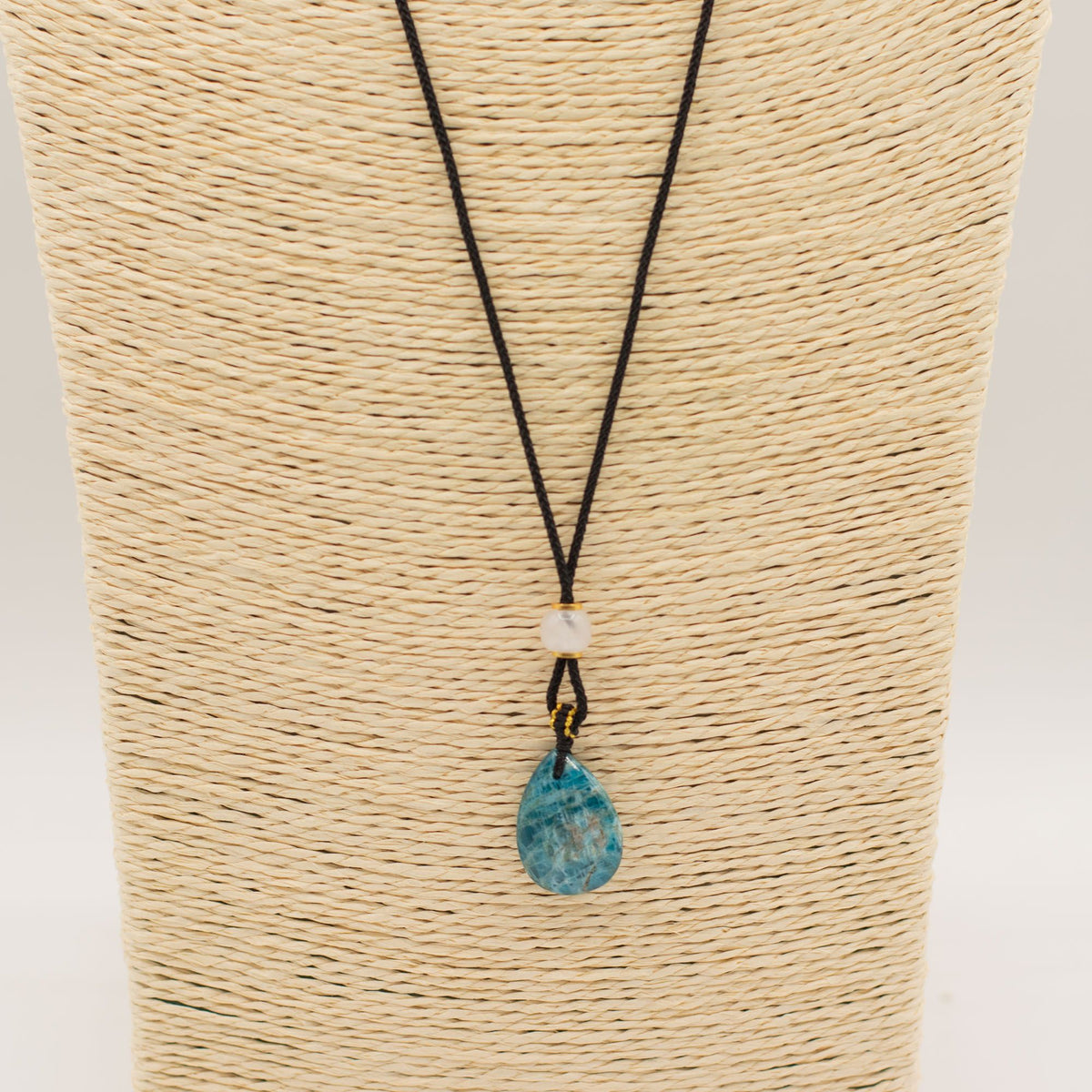 Cord Necklace Gemstone Pendant, Howlite Teardrop on a woven display bust, with a teal teardrop pendant