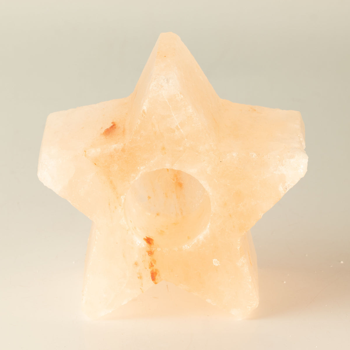 Star-shaped salt candle holder viewed from the front, showing the round candle well