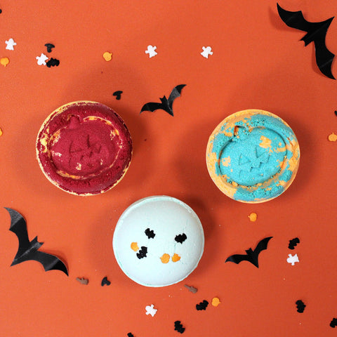 Coconut & Lime Halloween Bath Bombs in red, blue and pale green, viewed from above on an orange backdrop