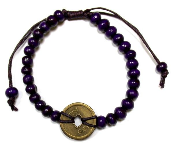 Purple bracelet with wooden beads and a coin at the centre