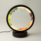 Gemstone halo lamp lit, showing its colourful stone ring and black frame