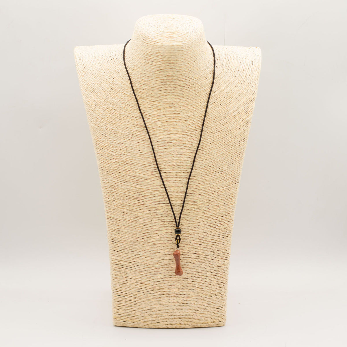 Cord Necklace Gemstone Pendant, Goldstone Bone, black cord displayed on a woven jewellery bust