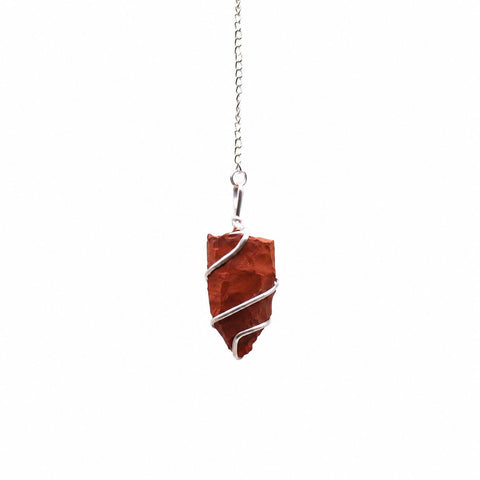 Red jasper pendulum hanging alone from a silver chain against a plain white background