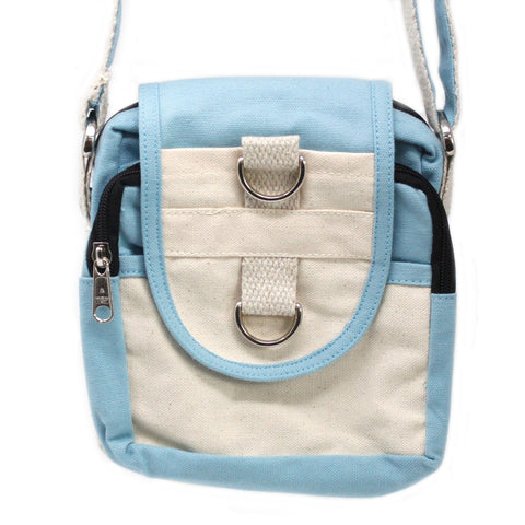 Front view of the teal and natural travel bag, showing its flap, metal rings and black zips
