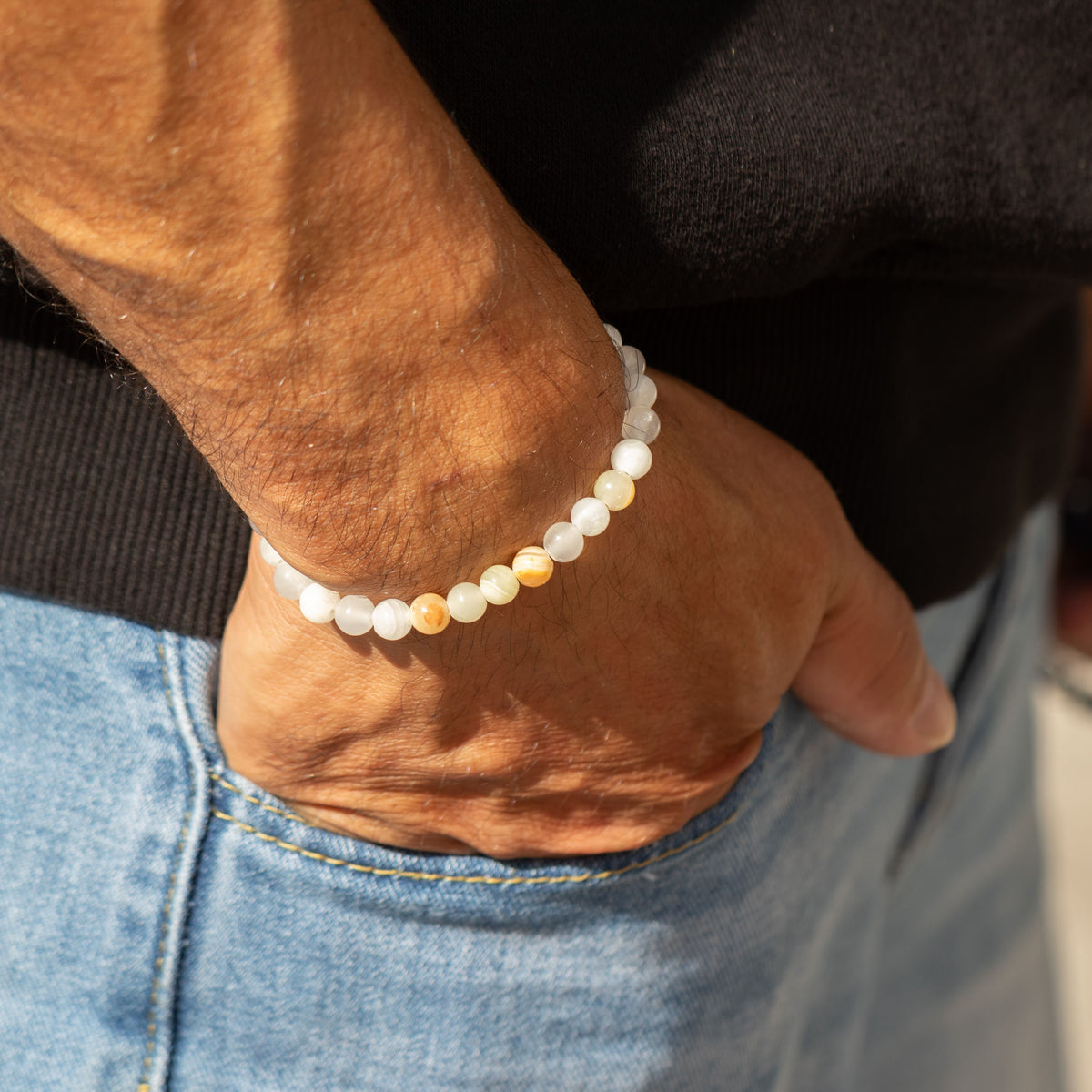 Bracelet worn on a wrist above jeans