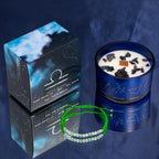 Libra zodiac candle and gift box on dark blue fabric, with the green cord gemstone bracelet in front