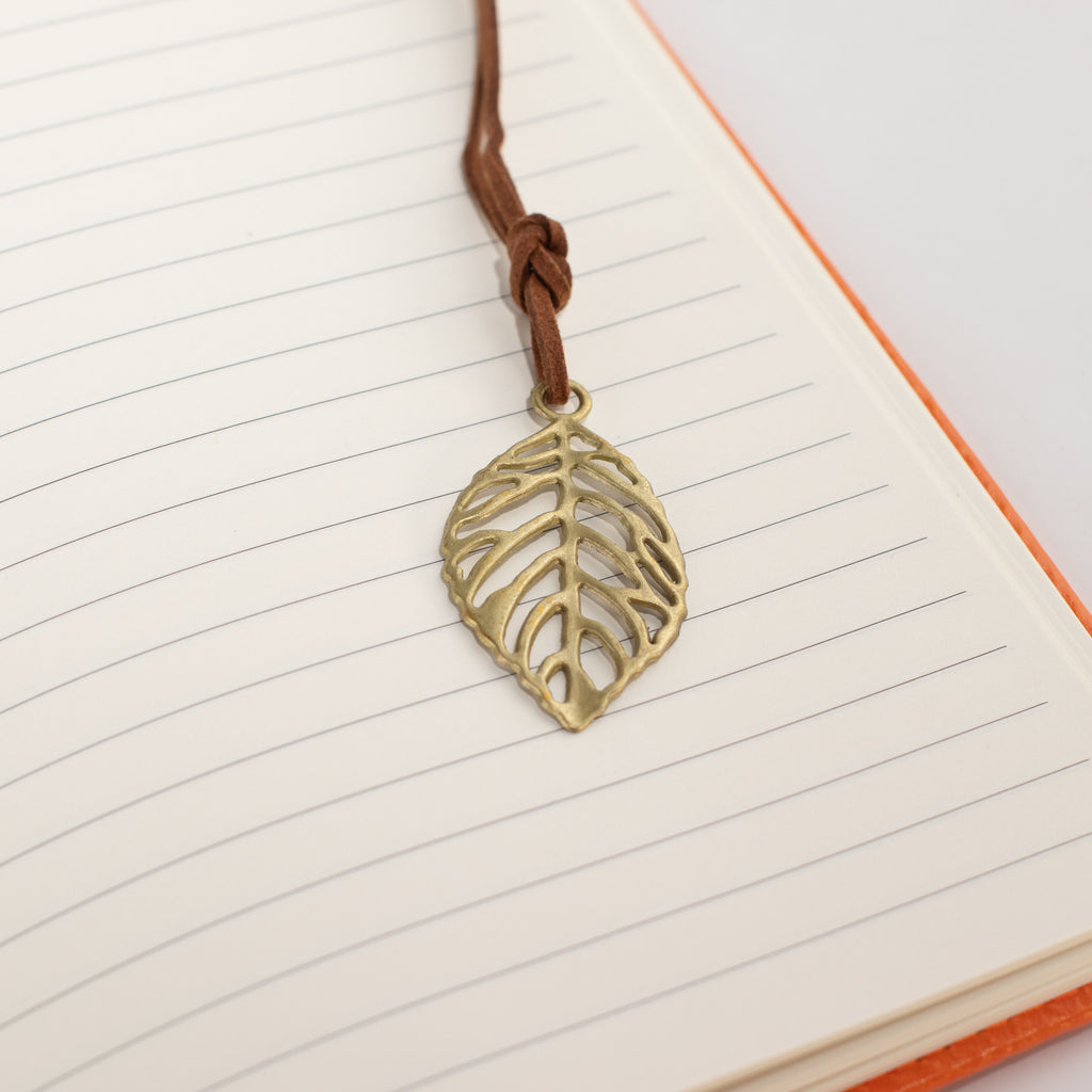 Leaf-shaped bookmark resting on lined notebook pages