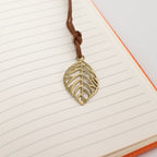 Leaf-shaped bookmark resting on lined notebook pages