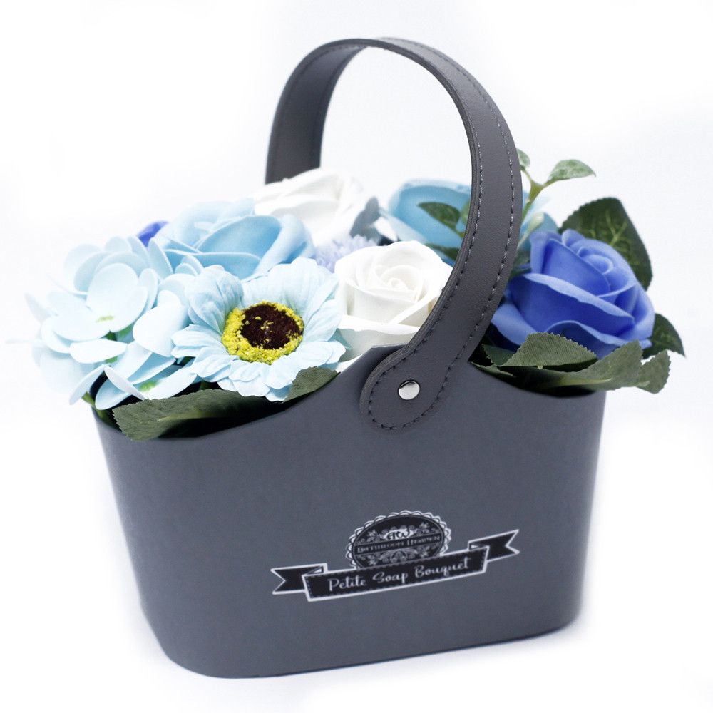 Petite soap flower bouquet in a grey handled basket, close-up against a white background