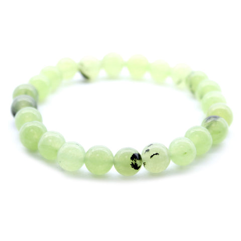 Close-up of the green jade beads in a bracelet against a white background